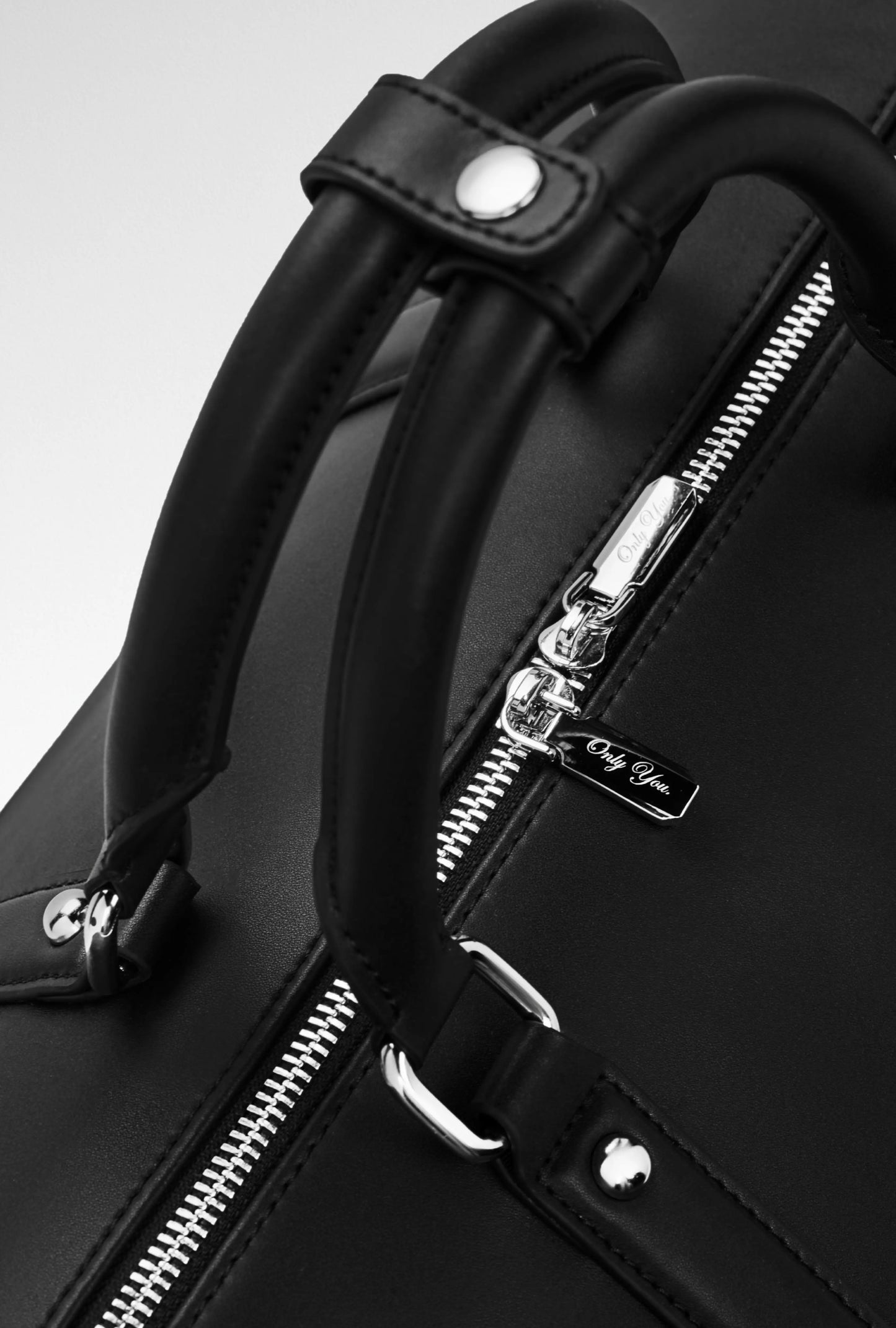 Hochwertige Tasche aus Mikrofaserleder mit Doppelreißverschlüssen und Gravur, Handgepäckgröße.